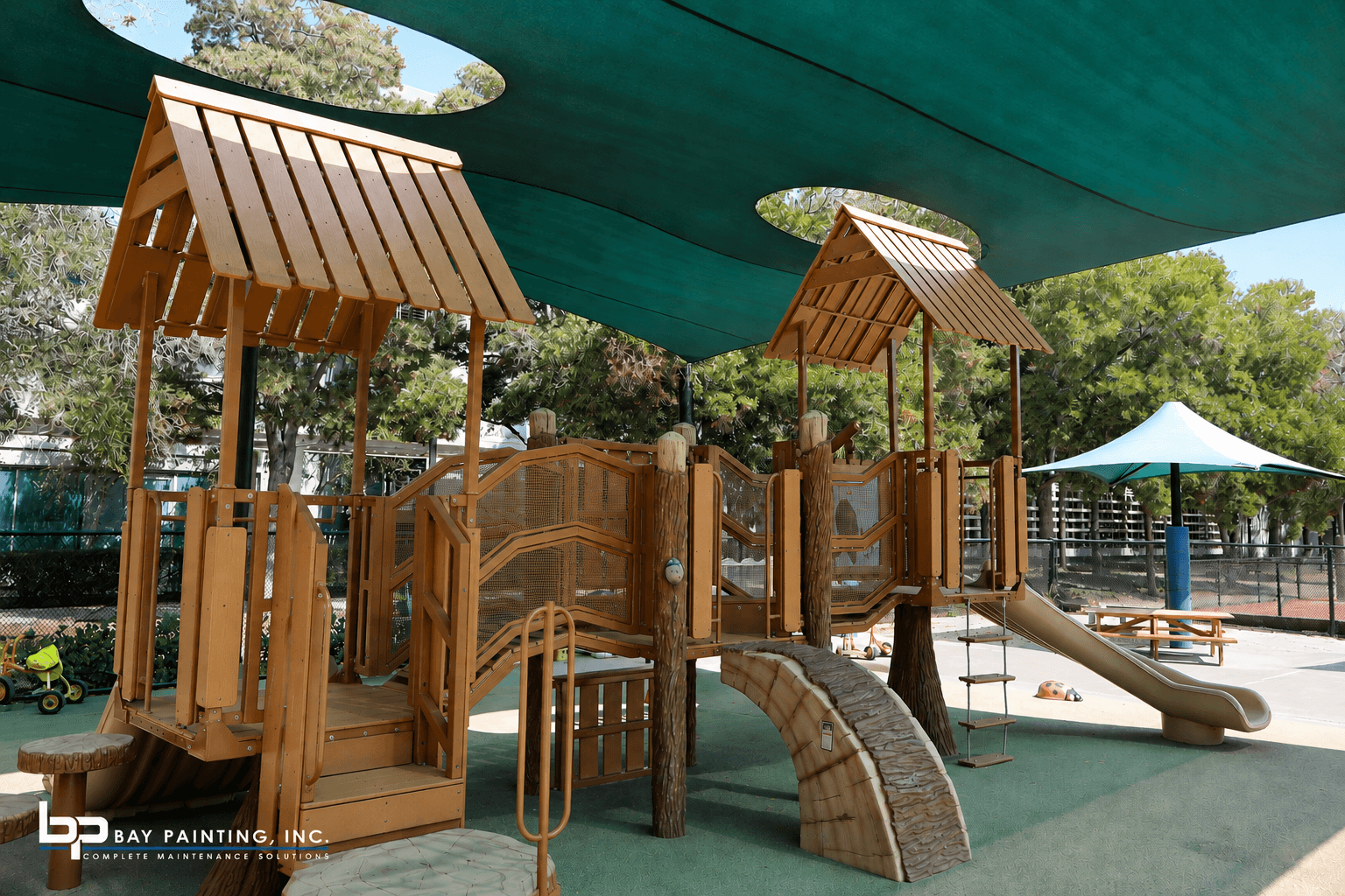Wood playground structure with green shade sails at a corporate campus in the Bay Area