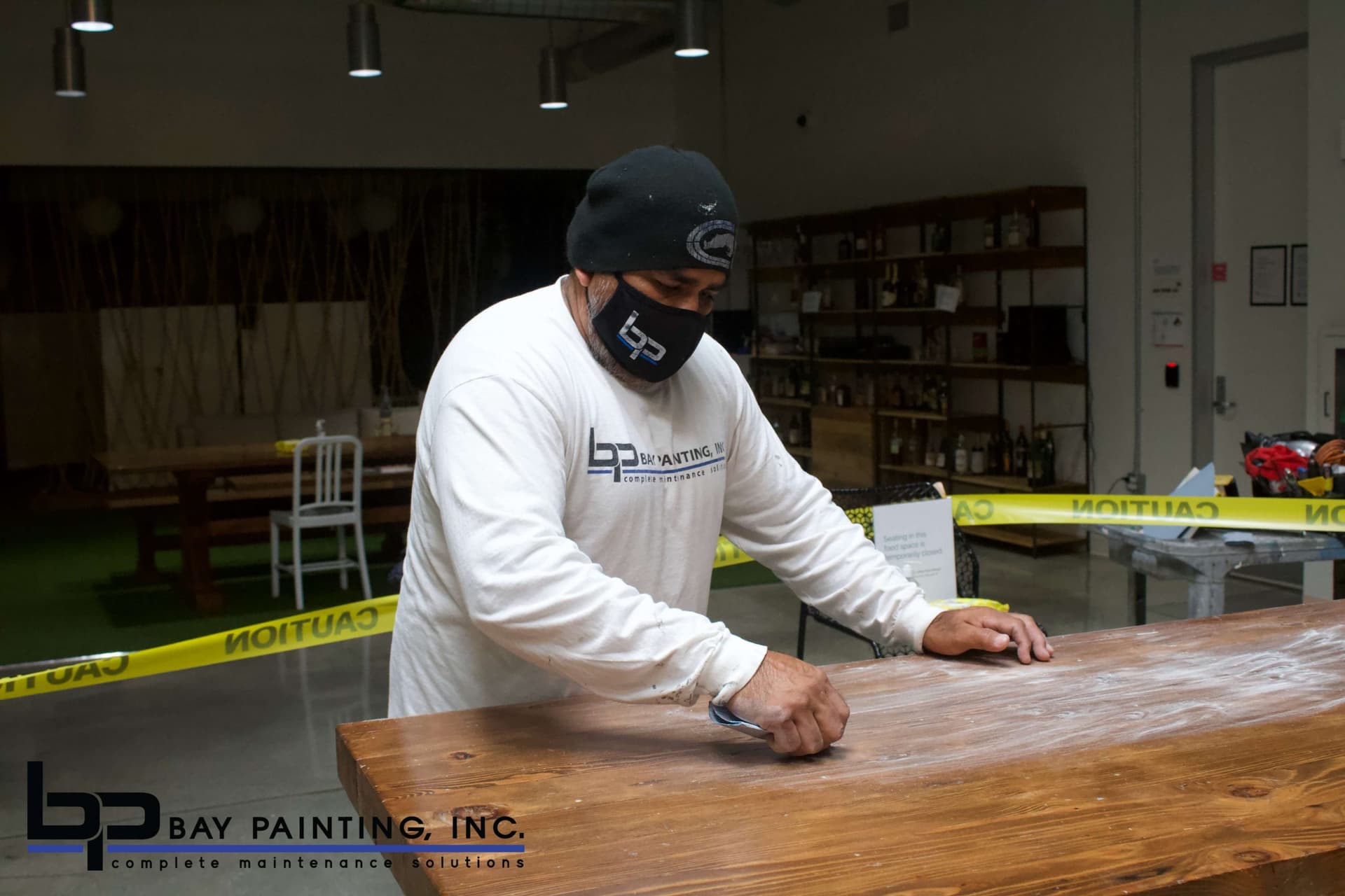 Painter on a scissor lift detailing exterior facade panels on a commercial building